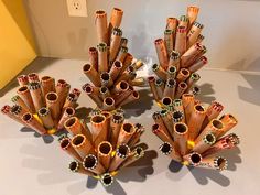 four pieces of art made out of rolled up pencils