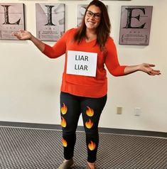 a woman wearing leggings with flames painted on them and holding her arms out