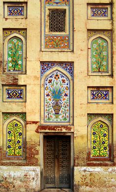 an old building with ornate designs on the front and side walls, including a door