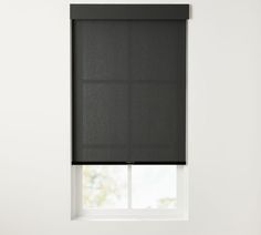 a black roller shade hanging on the side of a window in an empty room with white walls