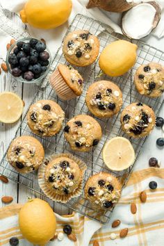 muffins with blueberries and almonds on a cooling rack next to lemons