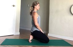 a woman sitting on a yoga mat in a room