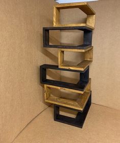 a stack of wooden shelves sitting on top of a cardboard box next to a wall