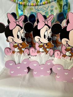 three minnie mouse cupcakes with pink bows and hearts on them, sitting next to each other