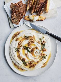 a white plate topped with hummus and crackers