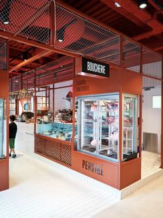 a person standing in front of a display case with food inside of it at a store