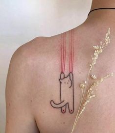 a woman with a cat tattoo on her back shoulder and arm, holding a flower