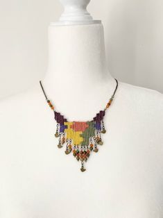 a white mannequin wearing a multicolored beaded necklace on it's neck