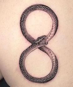 a snake tattoo on the back of a woman's lower back ribcage