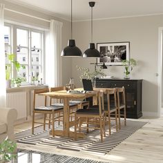 a dining room table and chairs in front of a window