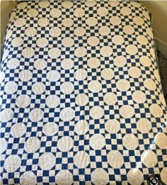 a blue and white checkered quilt on a bed