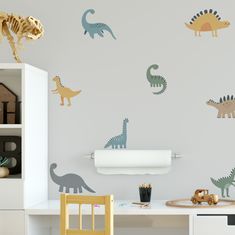 dinosaur wall decals in a children's room with toys on the desk and shelves