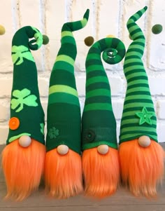 three green and orange gnomes with long hair