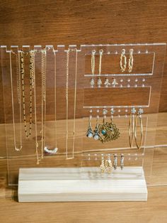 a clear acrylic display case with earrings and earring hooks on it's sides