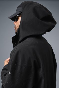 Stay dry without compromising style in this coat. It's stacked with functional features like a tall collar, a hood with bungees, zippered side pockets, and a secure zipper-and-snap front. Plus, it's made from soft, lightweight, 100 percent waterproof ripstop with a relaxed fit to accommodate movement. Cool on the streets? Yes. Suitable for stormy days? Also yes. Alo Yoga Winter Outdoor Outerwear, Alo Yoga Hooded Outerwear With Drawstring, Alo Yoga Winter Streetwear Outerwear, Alo Yoga Hooded Outerwear For Winter, Urban Black Raincoat For Fall, Black Functional Hooded Jacket For Rainy Weather, Black Functional Outerwear With Adjustable Hood, Functional Black Outerwear With Adjustable Hood, Alo Yoga Fall Outerwear With Drawstring Hood