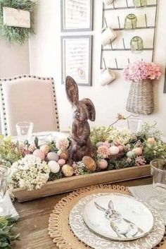 an easter table setting with bunny figurine in centerpiece and flowers on the side