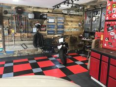 a garage with red and black checkered floors and lots of tools on the wall