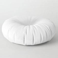 a white round pillow sitting on top of a table