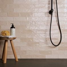 a bathroom with a white brick wall and black shower head