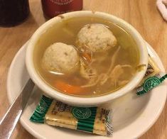 a white plate topped with soup and two dumplings