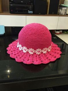 a pink crocheted hat sitting on top of a table