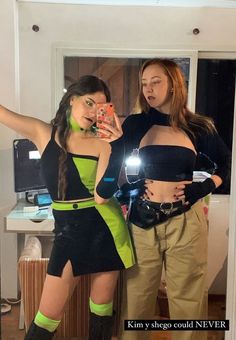 two women in costumes taking a selfie with their cell phone while standing next to each other