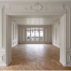 an empty room with white walls and wood floors