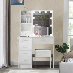 a white dressing table with lights on it in a living room next to a couch