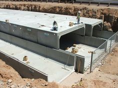 two men are standing on the side of a large building that's under construction