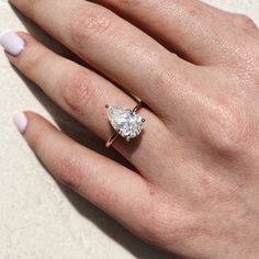 a woman's hand with a ring on her finger and a diamond in the middle