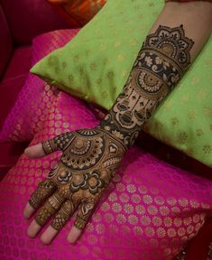 a woman's hand with henna tattoos on it