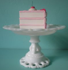 a piece of cake sitting on top of a white plate in front of a blue wall