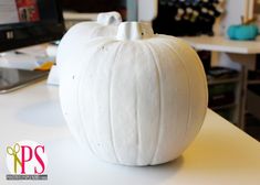 a white pumpkin sitting on top of a table