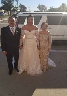 three people standing in front of a white truck wearing wedding gowns and tuxedos