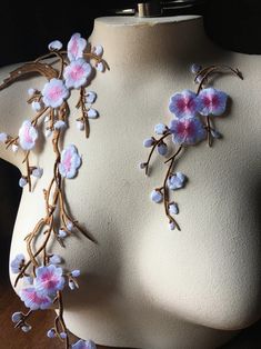 a white mannequin with pink and blue flowers on it's neckline