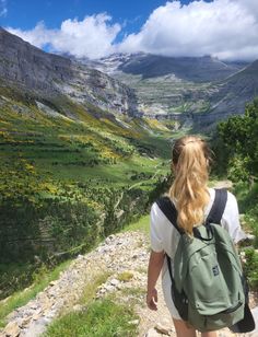 a woman with a backpack walking up a hill