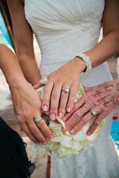 the bride and groom are holding hands with their grandmothers on their wedding day,