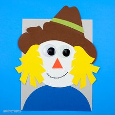 a paper cut out of a snowman wearing a brown hat and yellow ear pieces