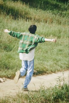 a young boy is running in the grass