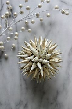 a white and gold decoration on a marble surface with berries in the foreground,