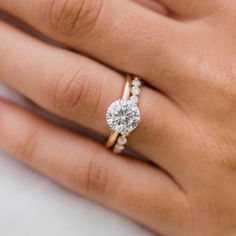 a woman's hand with a diamond ring on it