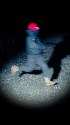 a blurry image of a person running in the dark with a frisbee