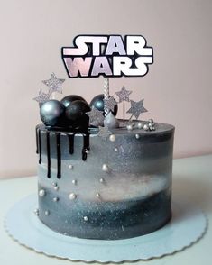 a star wars themed birthday cake with silver stars and black icing on it's top