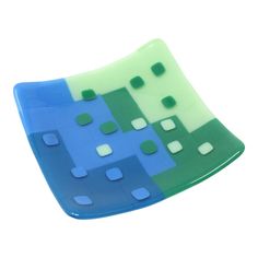 a blue and green glass plate with squares on the bottom, against a white background