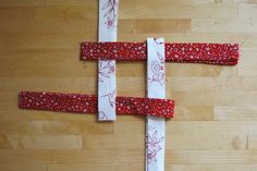 three pieces of paper are laid out on a wooden surface with red and white strips