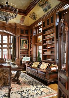 a living room filled with lots of wooden furniture and bookshelves covered in paintings