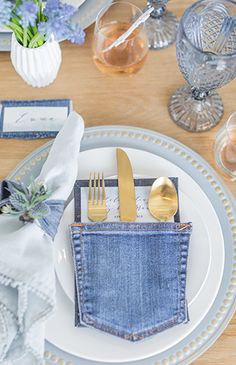 a place setting with blue denim napkins and silverware