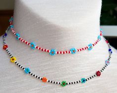 a white mannequin wearing a multi colored beaded necklace on it's neck