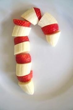 two bananas and strawberries are arranged in the shape of a candy cane