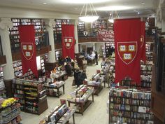 the inside of a bookstore with people browsing and looking at books on tables in front of them